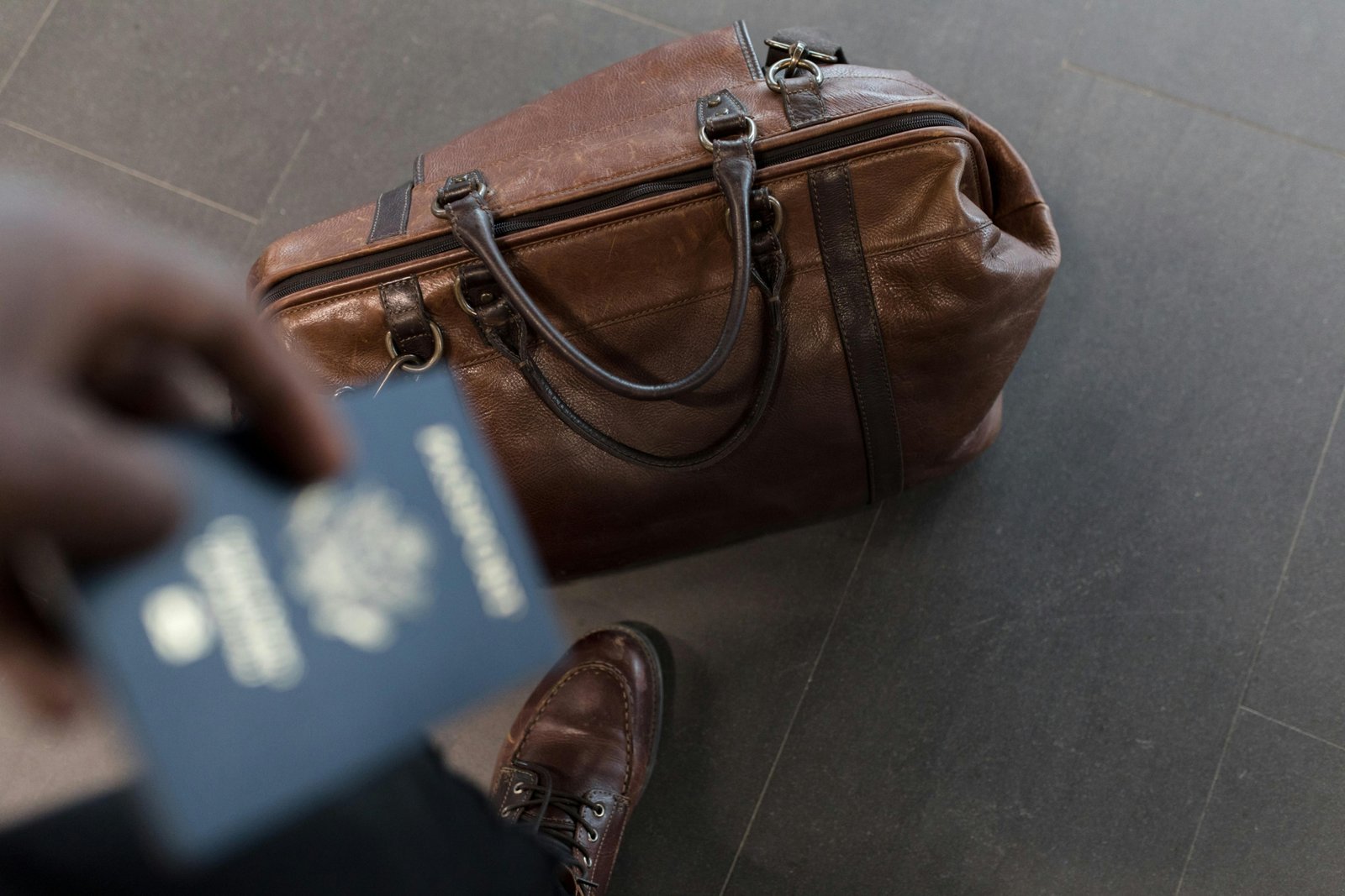 Male traveler holding an RFID-blocking travel wallet with a passport and multiple cards, showcasing secure and organized travel essentials for men.