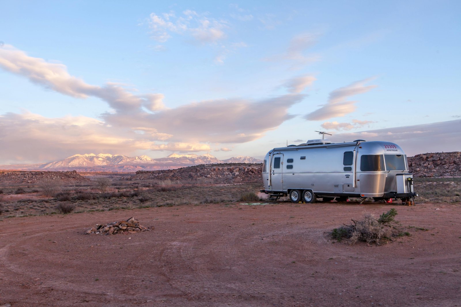 White Casita travel trailer (fiberglass RV) parked at a scenic lakeside campsite at sunset, symbolizing lightweight adventure and easy camping.