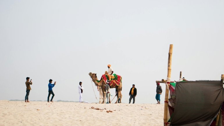 Diverse group of happy travelers on an organized Exoticca tour package, exploring an exotic landmark and highlighting the great value and adventure.