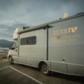 Lance travel trailer parked in a scenic natural environment, highlighting quality, comfort, and four-season camping for adventurous travelers.