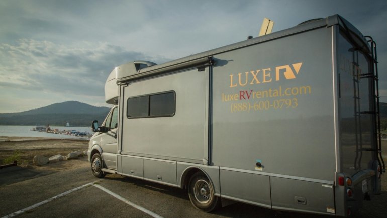Lance travel trailer parked in a scenic natural environment, highlighting quality, comfort, and four-season camping for adventurous travelers.