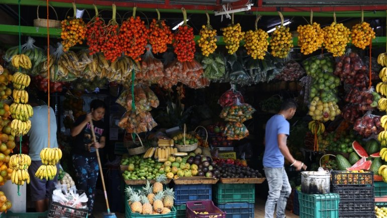Vibrant outdoor scene at Travelers Rest Farmers Market in South Carolina, featuring stalls overflowing with colorful fresh produce like fruits and vegetables, local artisan crafts, and shoppers enjoying the community atmosphere.