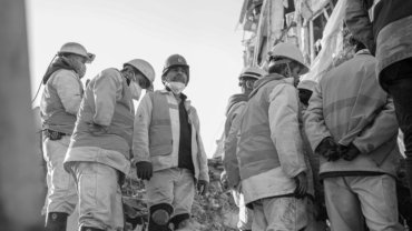 Diverse humanitarian aid workers providing emergency relief and support in a global disaster zone, representing traveling disaster relief jobs and community assistance.