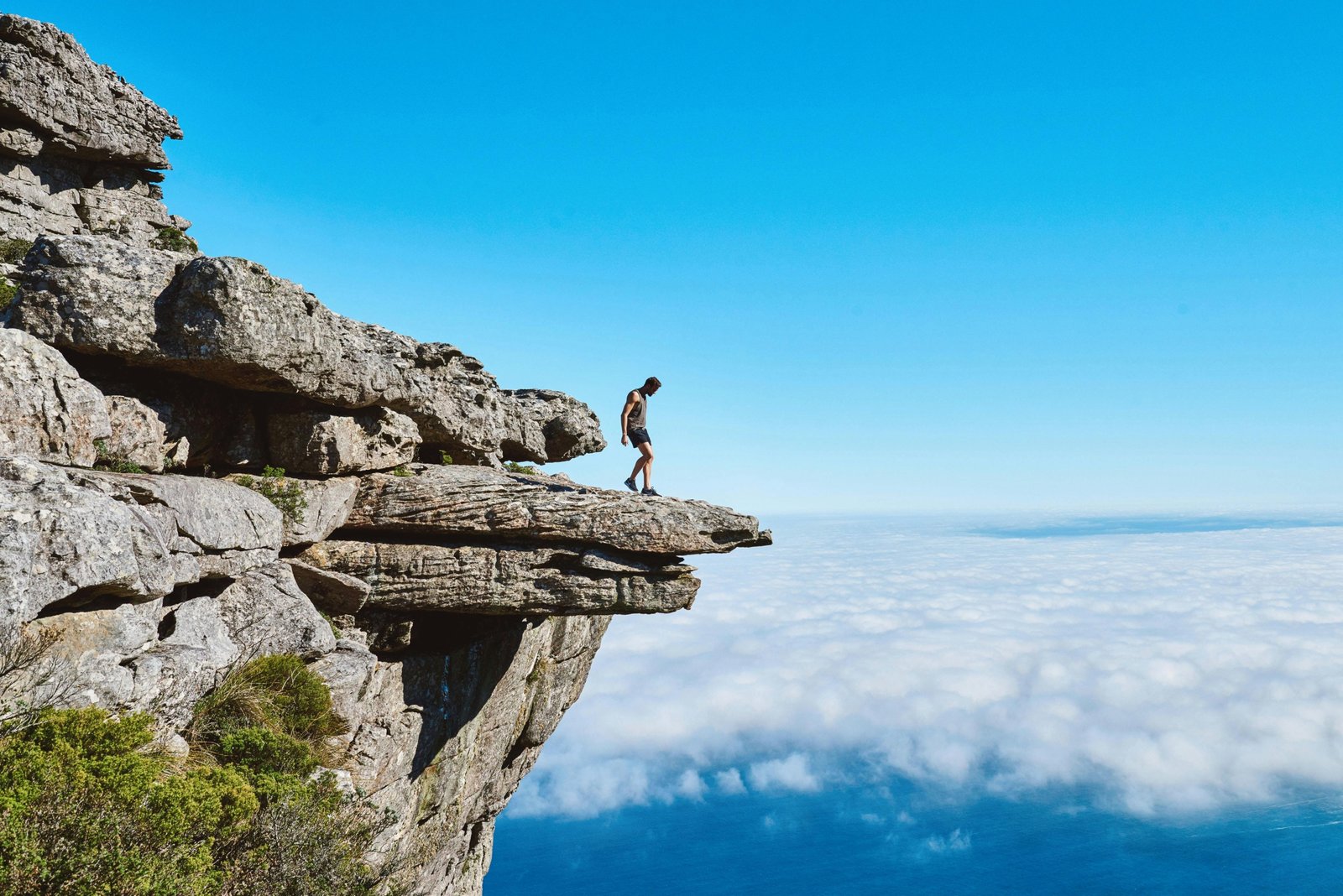 An adventurer stands with a backpack, gazing across a vast, breathtaking mountain range, inspiring exploration for overseas adventure travel in 2025 to destinations like Patagonia, Nepal, or the Azores.