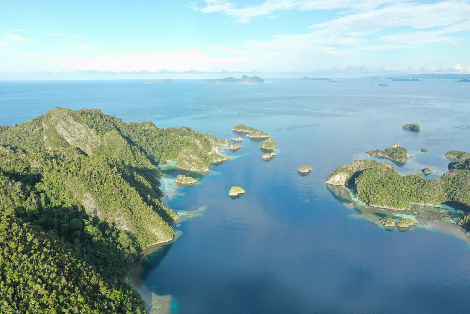 Hidden gems Oceania islands travel guide: Aerial view of a pristine, untouched Pacific island with turquoise lagoon and lush greenery, symbolizing secluded adventure and authentic discovery.