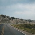 Scenic road winding through dramatic South Dakota landscapes, such as Badlands National Park or the Black Hills, ideal for an adventurous American road trip.