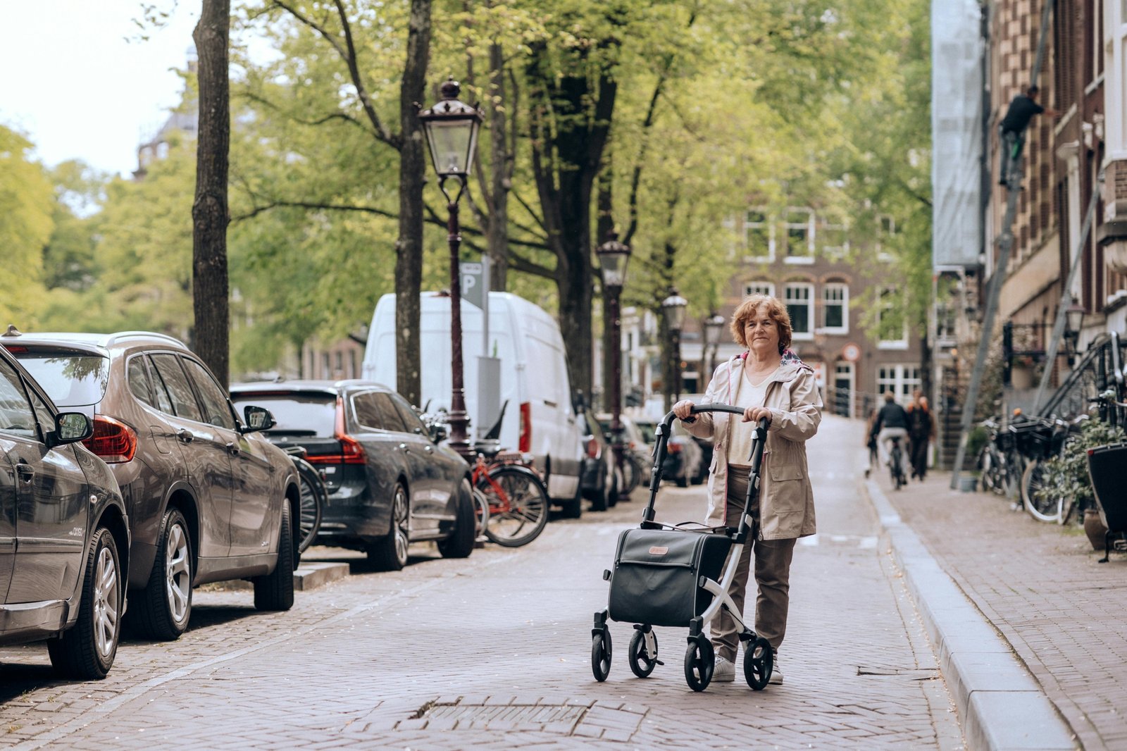 Happy senior traveler taking a rest on a lightweight folding travel walker with a seat in a scenic outdoor setting, symbolizing independence and the joy of exploring new places.