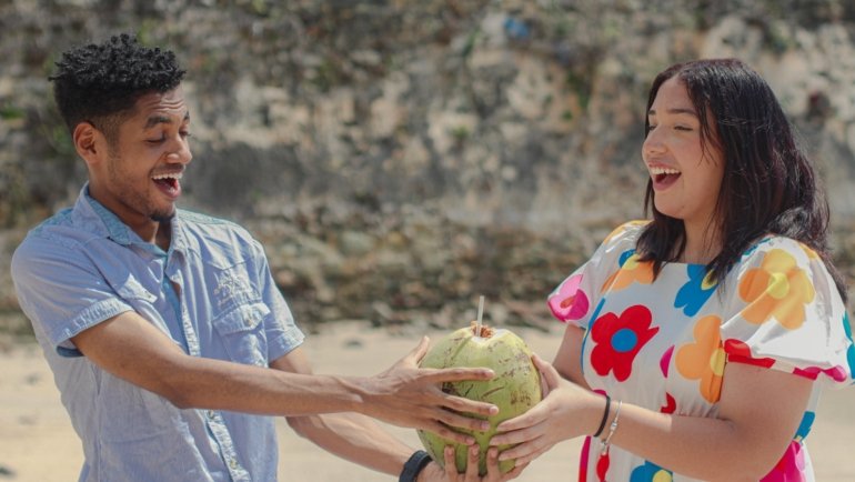 Vibrant Jamaican beach scene with turquoise waters, lush green palms, and happy travelers, embodying the island's rich culture and perfect tropical travel destination.