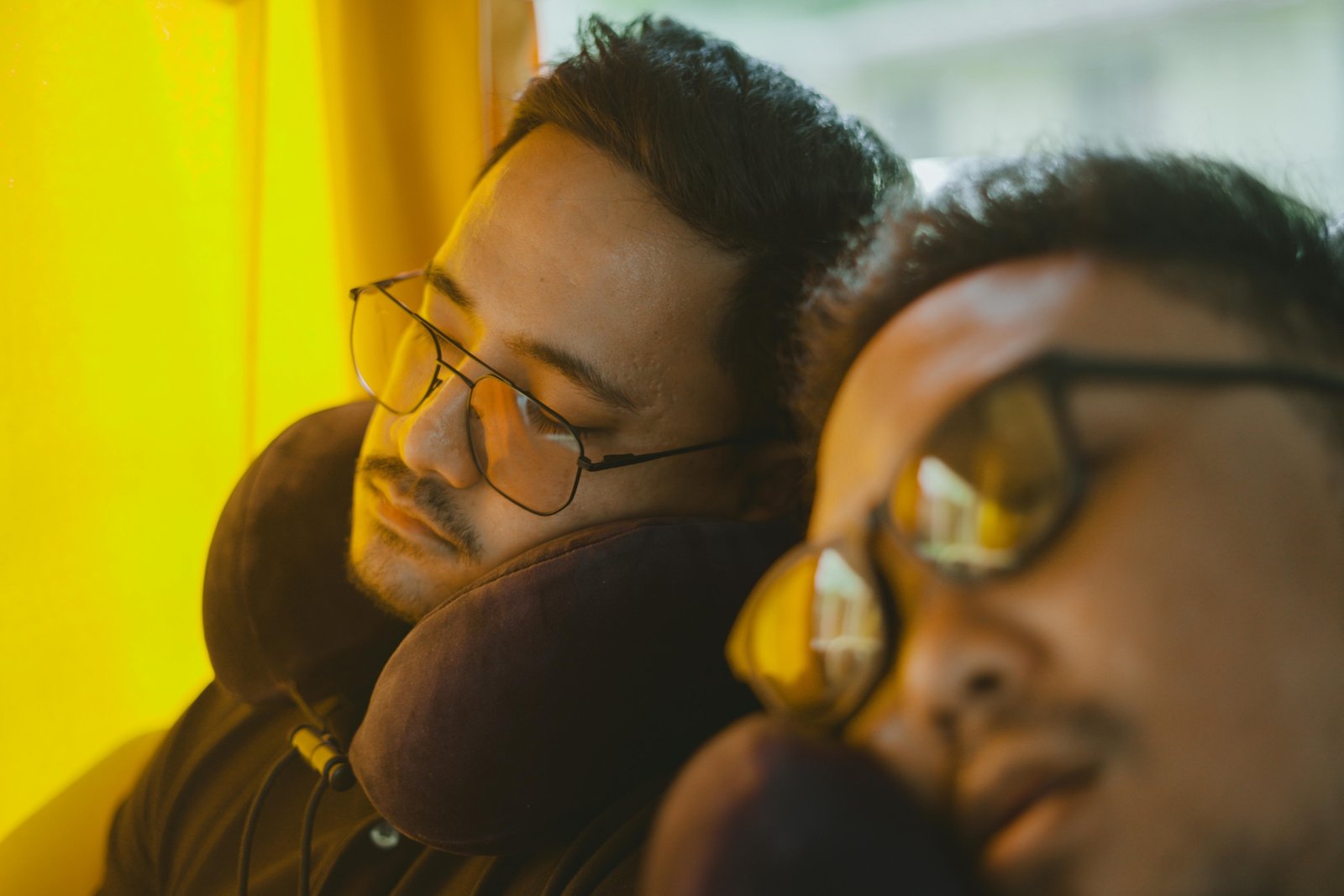 Person sleeping comfortably on airplane with ergonomic memory foam travel neck pillow, preventing neck pain and providing superior support.