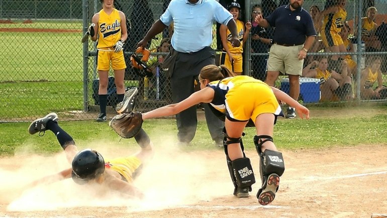 Competitive youth fastpitch softball team in action during a tournament, highlighting skilled young female players, teamwork, and passion for travel softball. Perfect for guides on finding teams and preparing for tryouts.