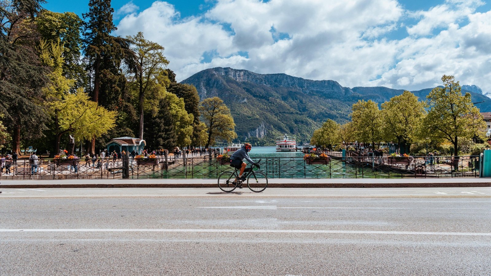 Travelers Rest, SC: People enjoying the vibrant small town main street and cycling on the Swamp Rabbit Trail, framed by the picturesque Blue Ridge Mountains, showcasing the ideal lifestyle for homes for sale.