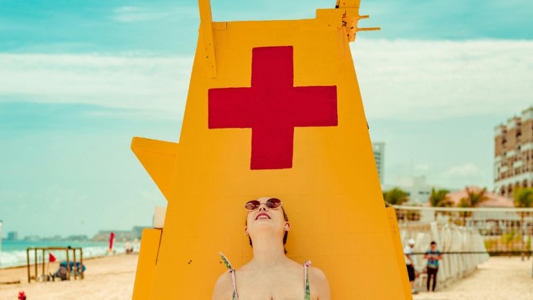 Happy traveler relaxing on a beautiful beach in Mexico, symbolizing the peace of mind and protection provided by comprehensive travel insurance for a worry-free vacation.