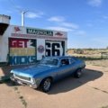 Sky City Travel Center in New Mexico desert, featuring gas pumps and a well-lit convenience store, serving as a vital rest stop for I-40 road trip travelers near Acoma.