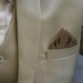 Hands demonstrating the inside-out fold method for packing a suit jacket, ensuring a wrinkle-free arrival for business travel.