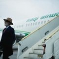 Stylish man confidently walking through an airport wearing a wrinkle-resistant men's travel blazer, showcasing professional yet comfortable business travel attire.