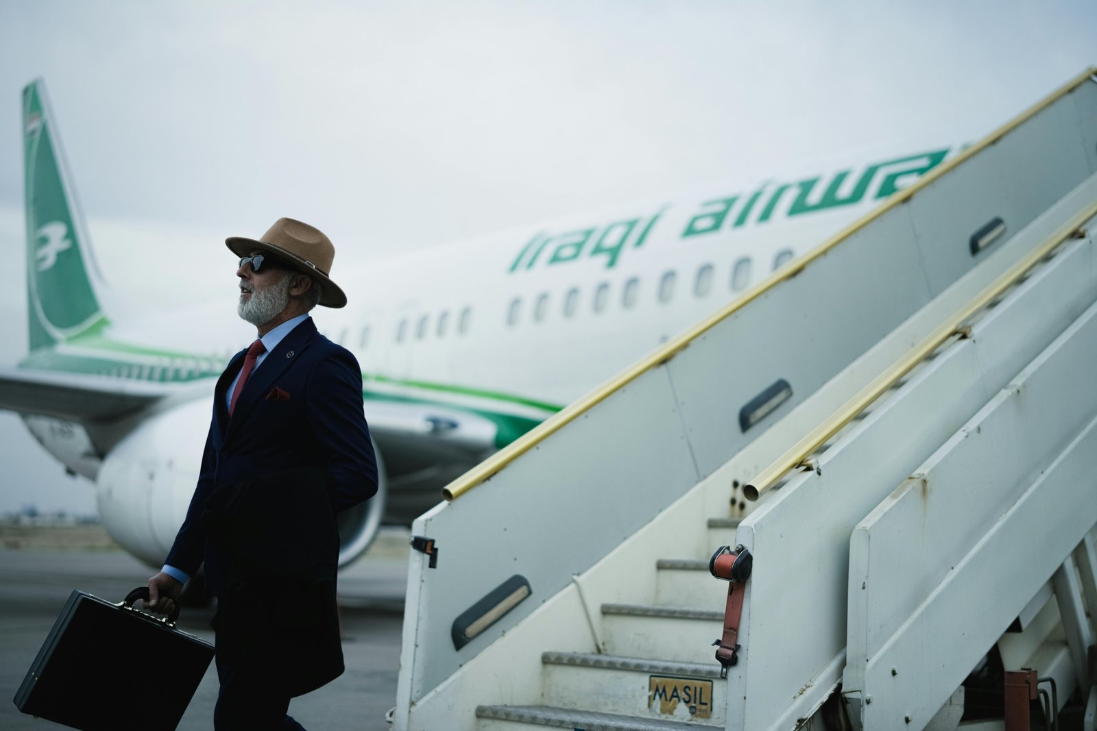 Stylish man confidently walking through an airport wearing a wrinkle-resistant men's travel blazer, showcasing professional yet comfortable business travel attire.