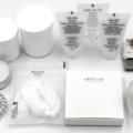 Oribe shampoo and conditioner travel size bottles arranged with luxury toiletries inside an open suitcase, perfect for TSA-approved elegant haircare on your next trip.