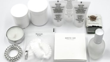Oribe shampoo and conditioner travel size bottles arranged with luxury toiletries inside an open suitcase, perfect for TSA-approved elegant haircare on your next trip.