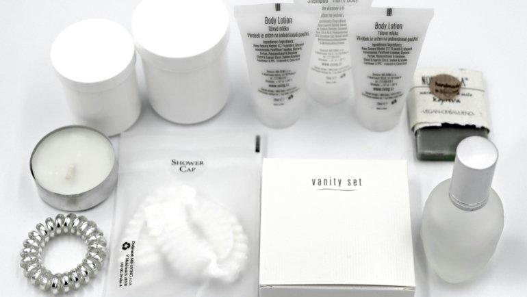 Oribe shampoo and conditioner travel size bottles arranged with luxury toiletries inside an open suitcase, perfect for TSA-approved elegant haircare on your next trip.