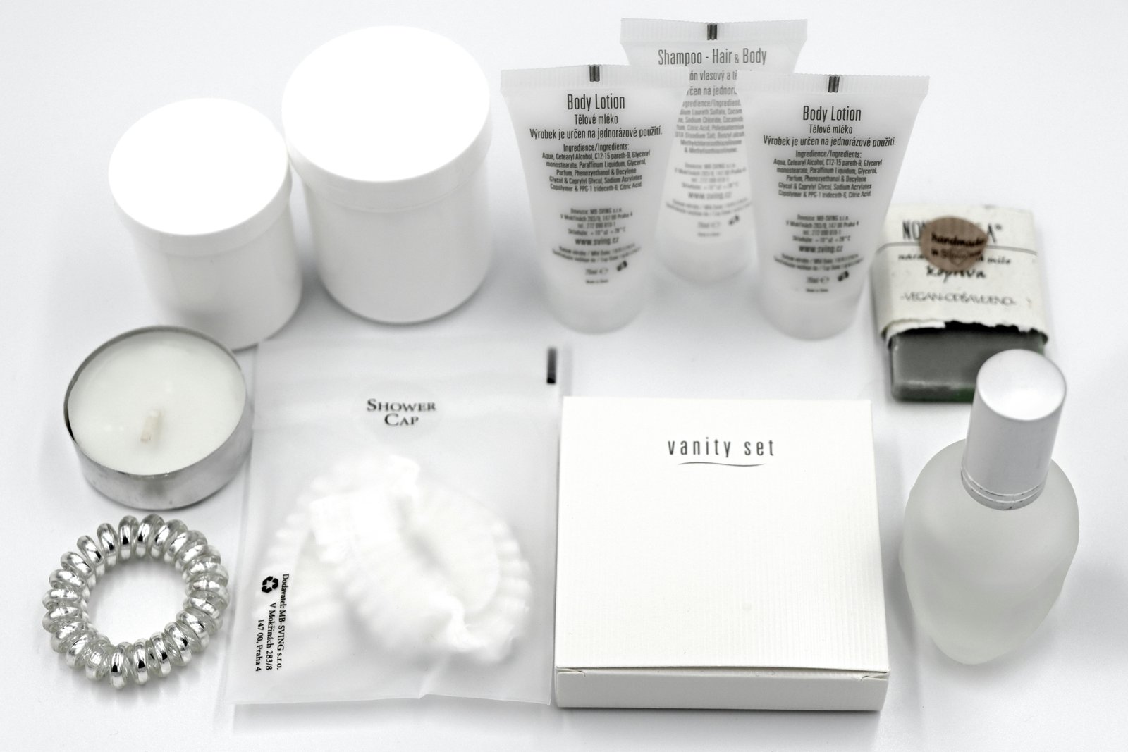 Oribe shampoo and conditioner travel size bottles arranged with luxury toiletries inside an open suitcase, perfect for TSA-approved elegant haircare on your next trip.