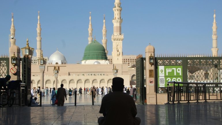 Muslim person reciting dua for travelling, seeking divine protection and peace of mind for a safe journey, reflecting faith and gratitude.