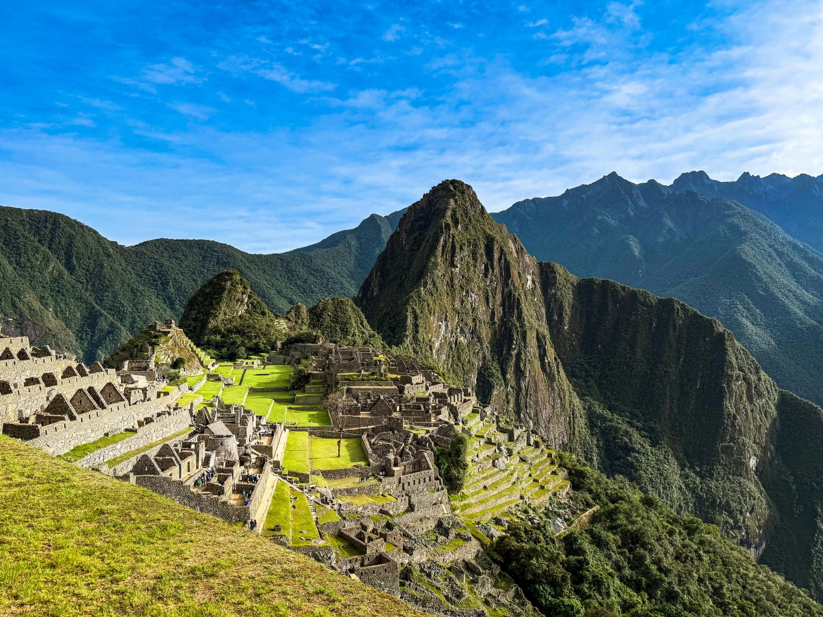 Panoramic view of Machu Picchu Inca citadel in Peru, showcasing its ancient ruins and lush Andes mountains under a clear sky, illustrating the best time to visit for an unforgettable trip.
