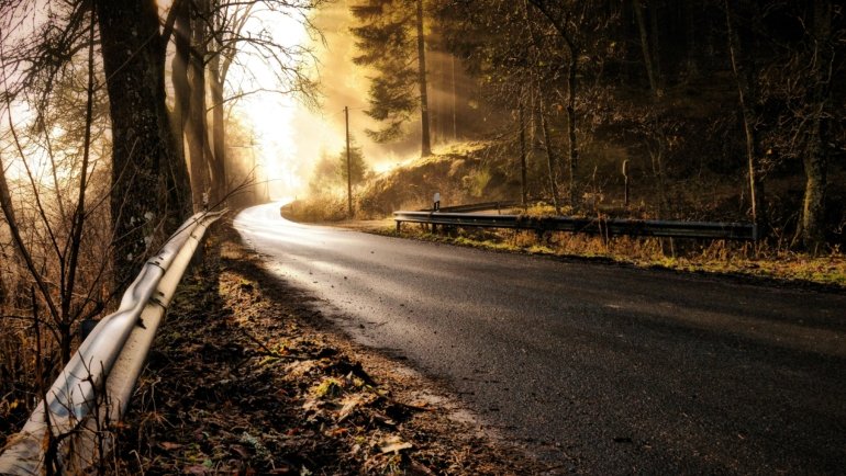Beautiful landscape of an open road leading towards a sunrise, symbolizing safe travels, good wishes, and new adventures for a memorable journey, as discussed in the article about finding perfect travel images.
