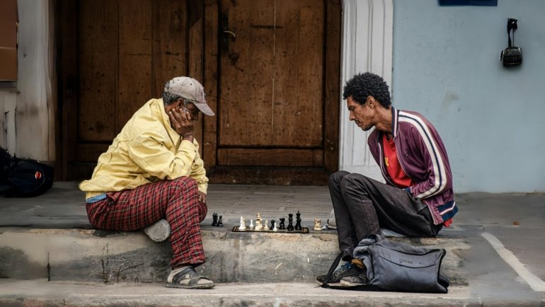 Politicser.com Pepperboy travel archives: A solo backpacker engaging with locals in an authentic, off-the-beaten-path destination, embodying budget-friendly adventure.