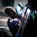 Skilled traveling welder sparks flying on an industrial construction site, highlighting a high-demand, high-paying career in oil and gas or power generation.