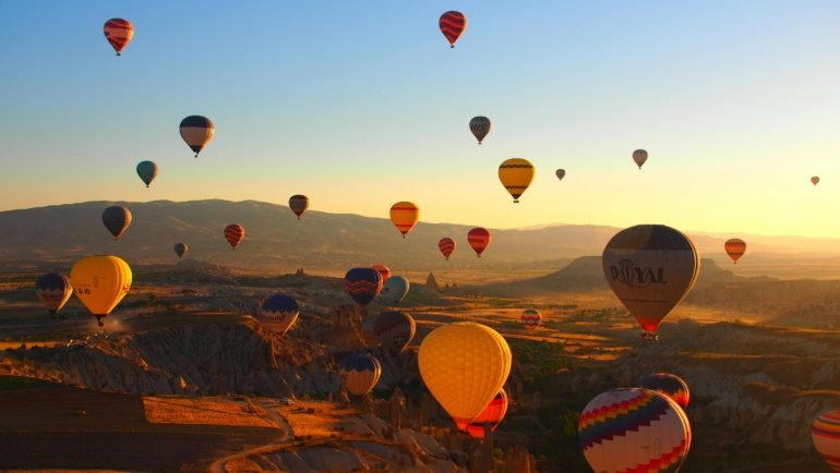 Overview of iconic Turkish travel destinations, featuring historical landmarks like Istanbul and ancient ruins, alongside unique landscapes such as Cappadocia's fairy chimneys.