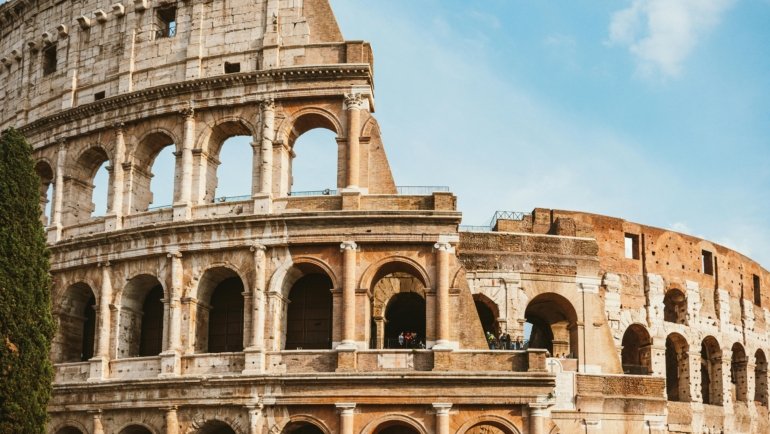Happy travelers exploring an iconic Roman landmark, illustrating the joy and convenience of Rome travel packages for a dream Italian vacation.