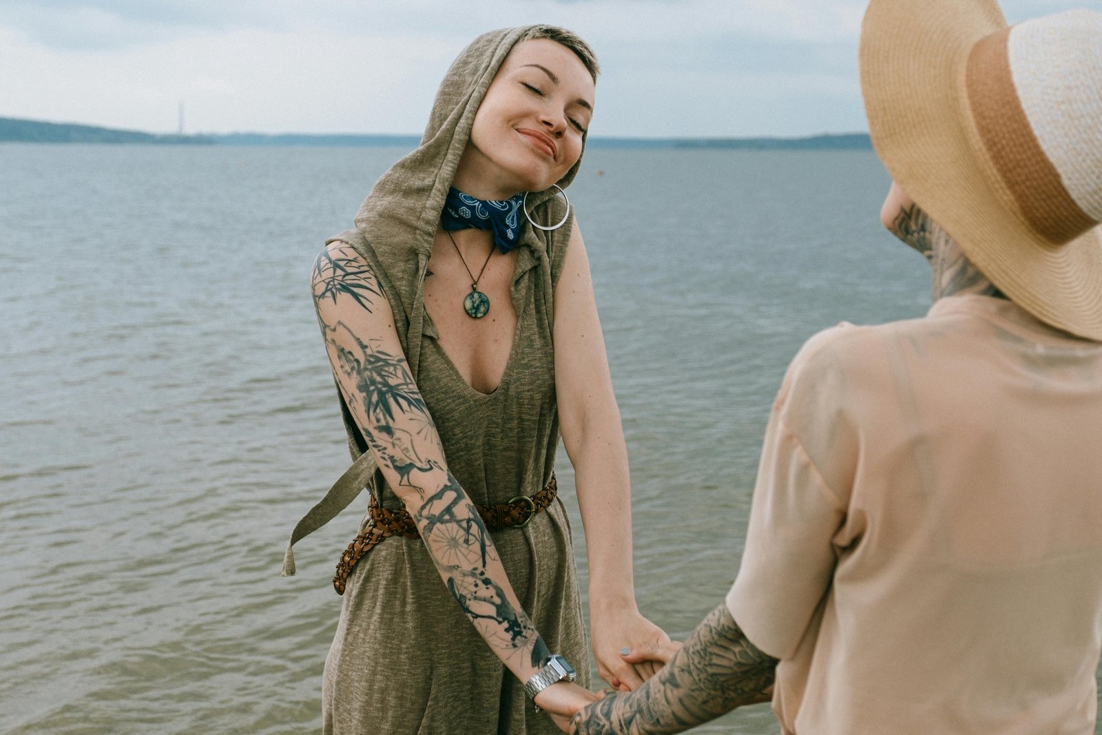 Couple embracing freedom and nature on a clothing-optional beach, symbolizing body positivity, self-acceptance, and the liberating philosophy of naturist travel.