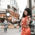Stylish woman in a comfortable, wrinkle-resistant travel dress exploring a vibrant city street, embodying versatile female travel fashion and smart packing.
