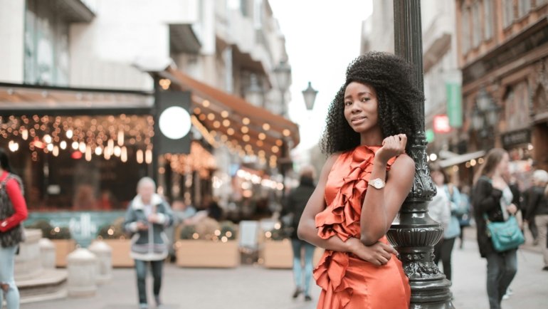 Stylish woman in a comfortable, wrinkle-resistant travel dress exploring a vibrant city street, embodying versatile female travel fashion and smart packing.
