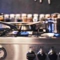 Modern propane stove in a cozy travel trailer kitchen, actively used for cooking a delicious meal, highlighting the convenience and off-grid capability for RV and camping adventures.