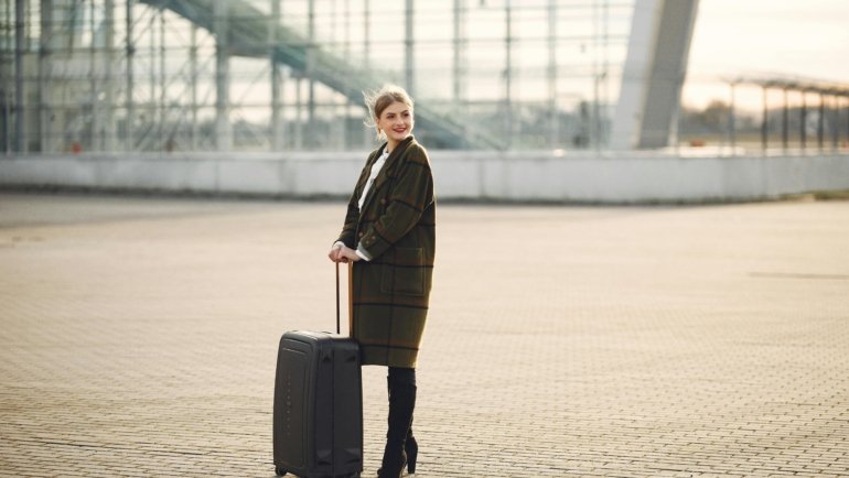 Stylish person with a luxury Gucci-style travel bag in an elegant airport terminal, showcasing high-end travel and iconic design.