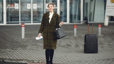 Stylish Steve Madden travel bag set (carry-on and checked bag) with spinner wheels, being effortlessly pulled by a fashion-forward traveler in a modern airport terminal.