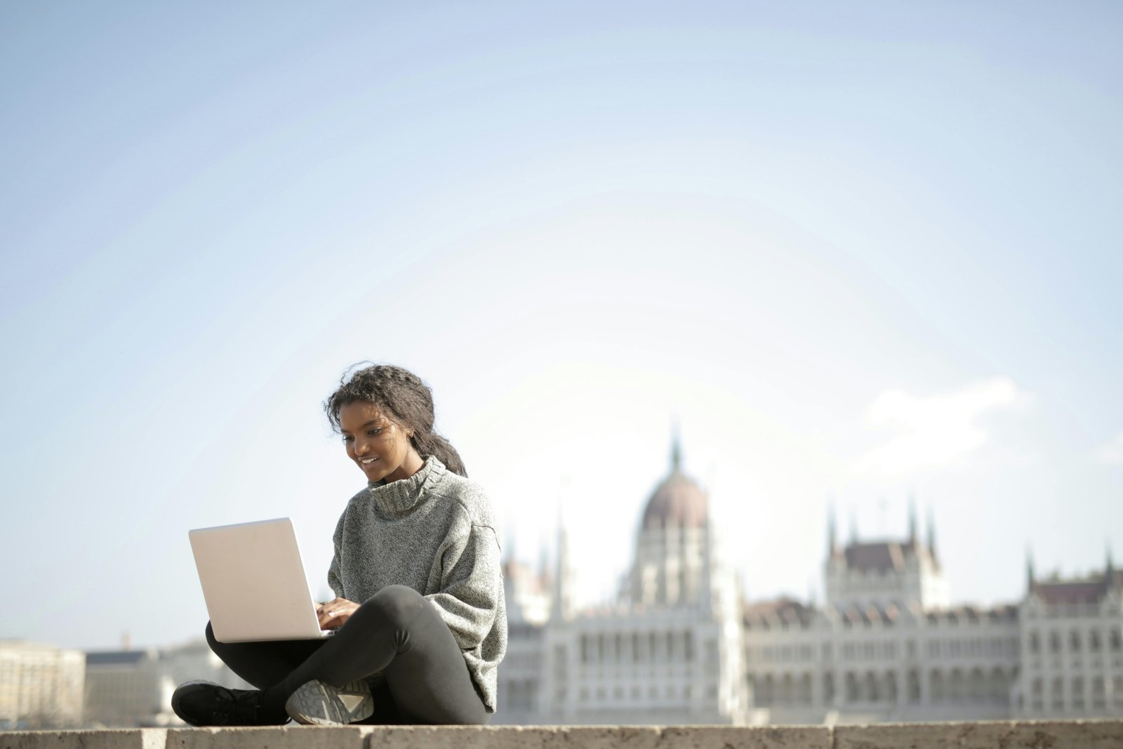 Happy travel nurse working remotely on a laptop, symbolizing flexible part-time telehealth jobs and a balanced career.