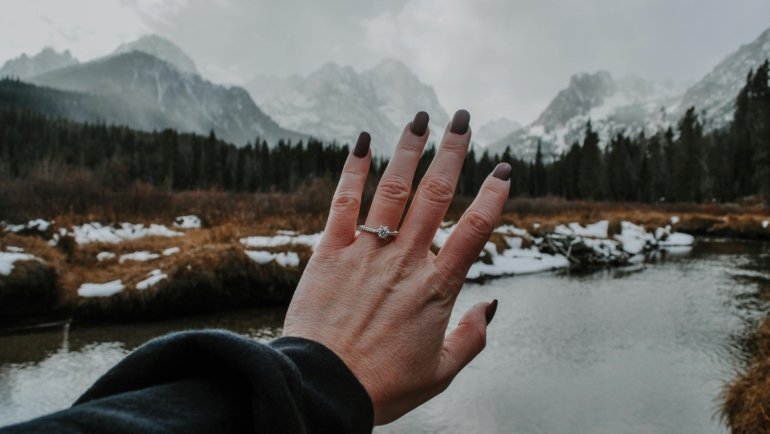 Hand wearing a stylish travel ring (an affordable alternative to an engagement or wedding ring) while on a beautiful vacation, illustrating worry-free travel and protection of precious jewelry.