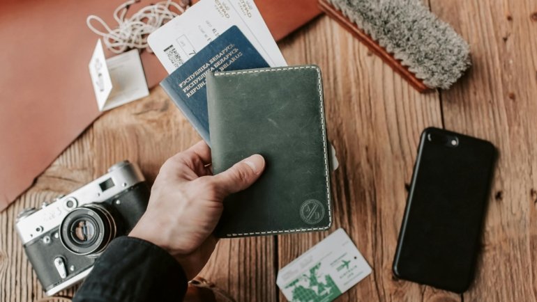 Travel document holder with passport, boarding pass, and credit cards neatly organized, held by a traveler for secure and stress-free journeys.