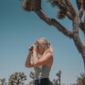 A traveler captures a stunning scenic landscape with a compact travel camera, emphasizing the joy and ease of creating memorable vacation photographs.