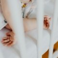 A baby sleeping soundly in a portable travel crib, emphasizing safety and comfort for worry-free family adventures.