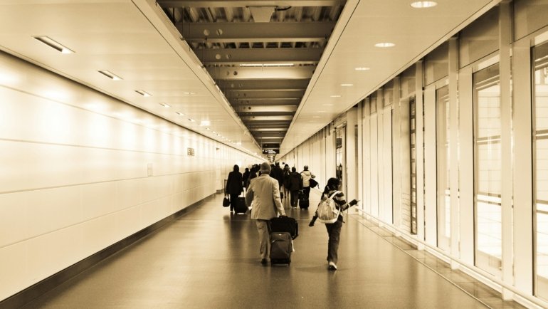 Compact travel stroller at an airport gate, demonstrating ease of use for families flying with a child, perfect for airplane carry-on and smooth travel.