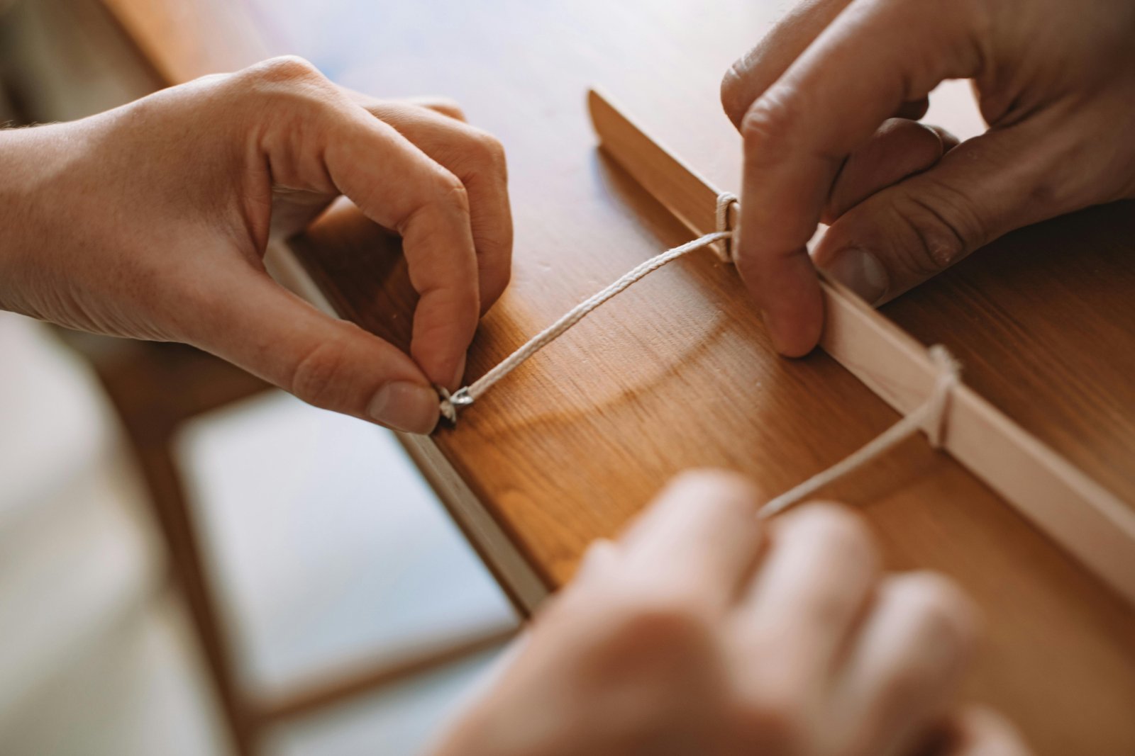 Close-up of an angler's hands expertly tying a detailed fishing fly on a Renzetti Traveler rotary vise, showcasing precision, craftsmanship, and the enjoyment of the fly tying process.