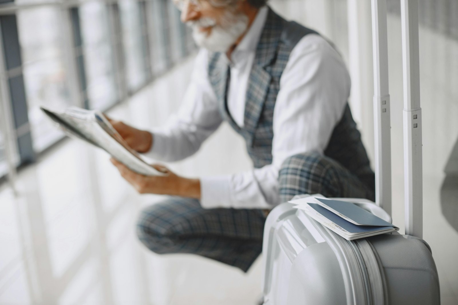 A U.S. Green Card holder reviewing their passport and Green Card at an international airport, emphasizing careful preparation for international travel and understanding re-entry rules for permanent residents.