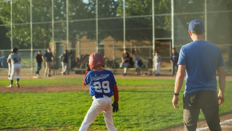Competitive youth travel baseball team playing a game on a field, illustrating the pursuit of top rankings and player development.