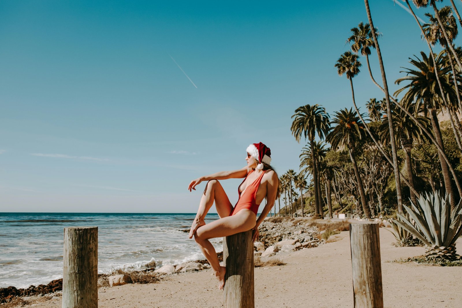 A stunning tropical beach scene with clear turquoise water, white sand, and people enjoying the sun, illustrating an ideal warm place to travel in December for a winter sun vacation.