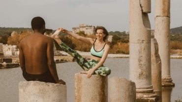 Two sisters performing a bodyweight workout on a scenic beach, representing the 'Wellness Wanderers' travel fitness health wellness duo and their tips for a healthy, balanced nomadic lifestyle.