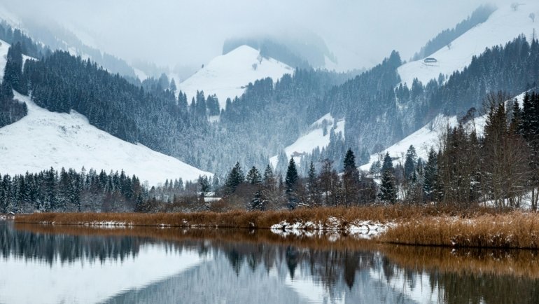 Scenic view of Swiss mountains and a crystal-clear lake, perfect for an unforgettable trip to the best places to travel in Switzerland.