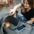 Active parents navigating a park with a modern baby travel system, featuring an infant car seat seamlessly attached to a stroller, showcasing convenience for safe and easy baby travel.